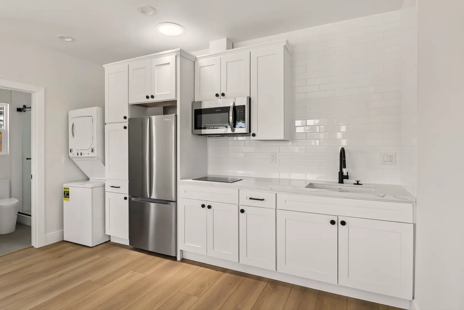 49th Street garage conversion — kitchen with full appliances and stacked laundry